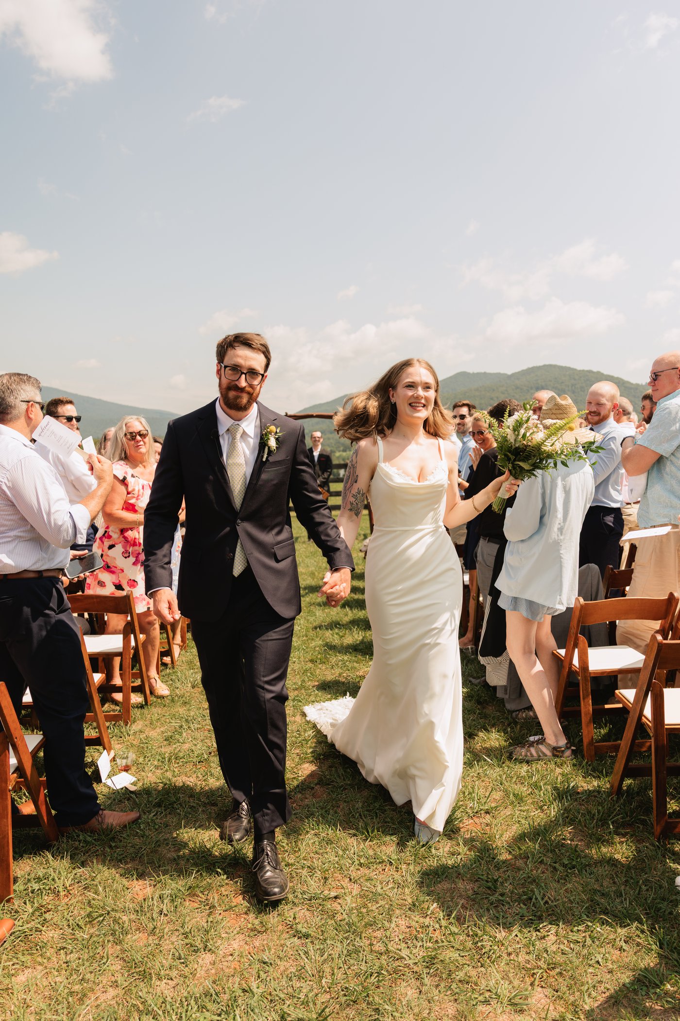 Breanne and Josh celebrating their wedding recessional under open sky